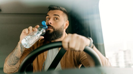 commercial driver sipping from a bottle